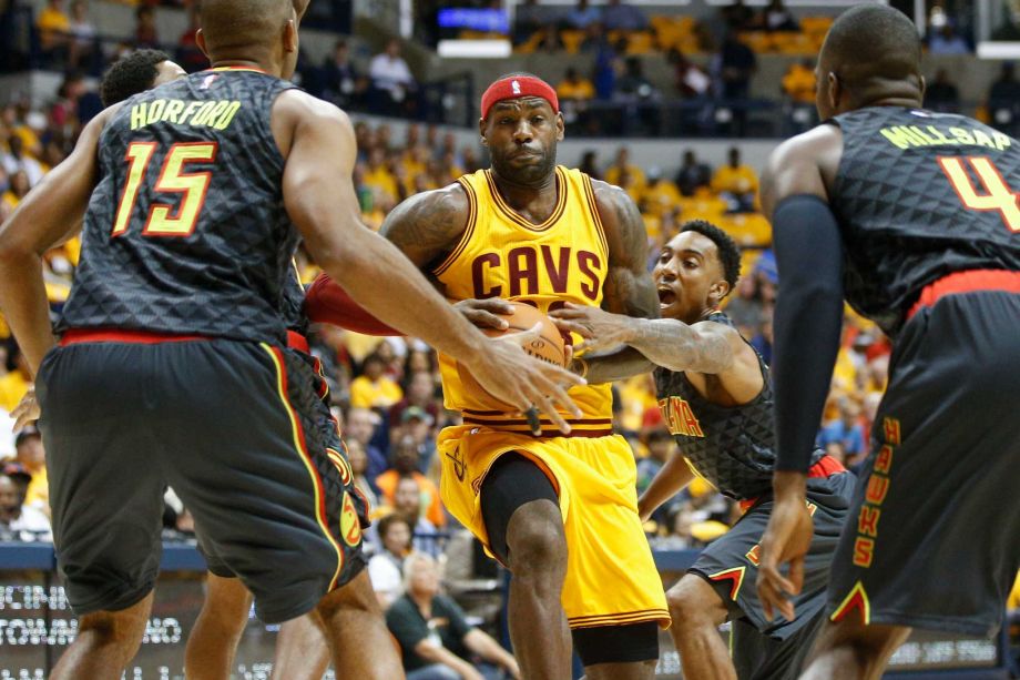 Atlanta Hawks guard Jeff Teague center right reaches for the ball on a drive by Cleveland Cavaliers forward Le Bron James center in the first half a preseason NBA basketball game Wednesday Oct. 7 2015 in Cincinnati