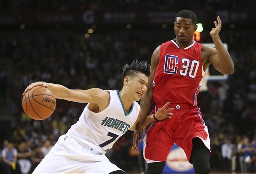 The Charlotte Hornets guard Jeremy Lin drives past Los Angeles Clippers guard CJ Wilcox during the fourth quarter of the 2015 NBA Global Games in Shenzhen south China's Guangdong province Sunday Oct. 11 2015