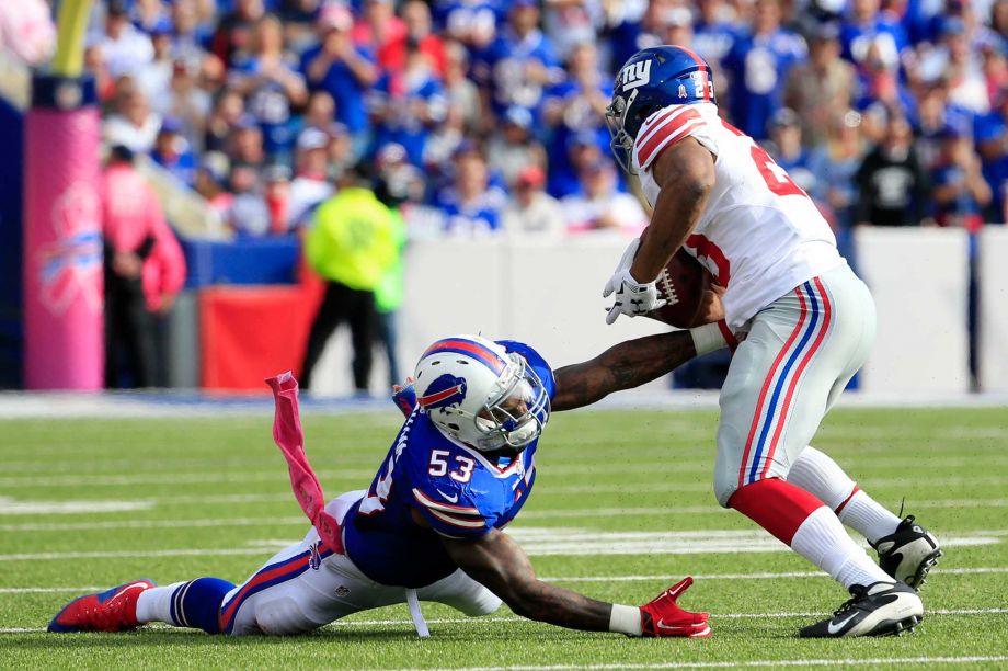 New York Giants running back Rashad Jennings right breaks a tackle attempt by Buffalo Bills outside linebacker Nigel Bradham on his way to score a touchdown run during the second half of an NFL football game Sunday Oct. 4 2015 in Orchard Park N.Y