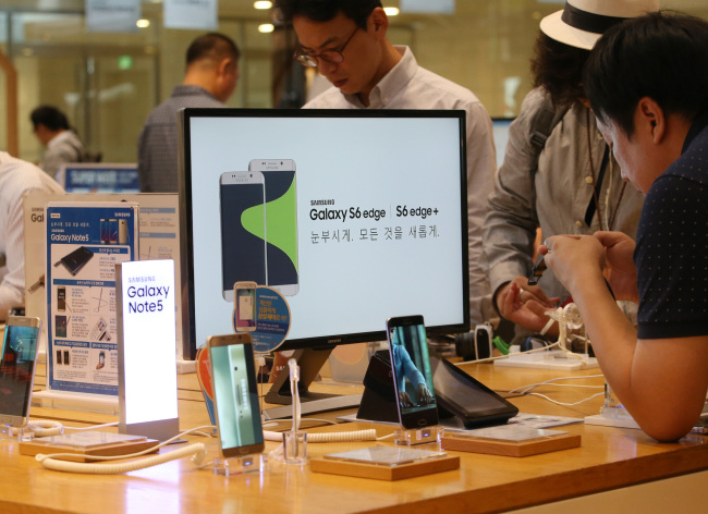 Customers try out Samsung devices at a store near the company`s headquarters in Seocho-dong southern Seoul on Wednesday. Yonhap