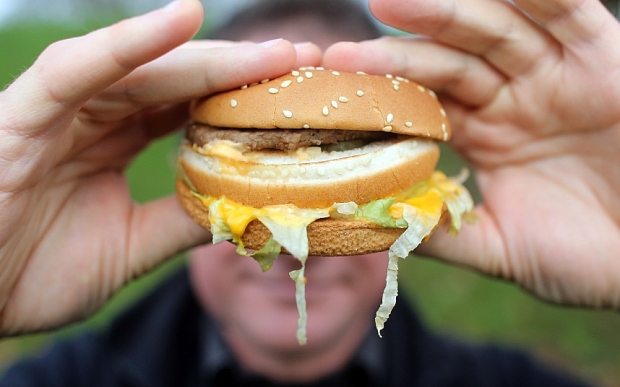 A man holds a burger from a fast food outlet