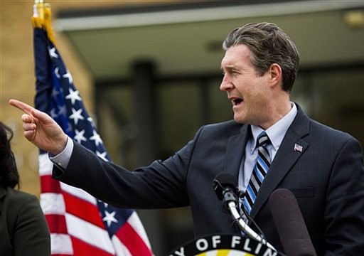 Flint Mayor Dayne Walling speaks during a news conference Friday Oct. 16 2015 outside Ralph M. Freeman Elementary School in Flint Mich. Flint officials say they have reconnected to Detroit's water system as they work to resolve a health emergency