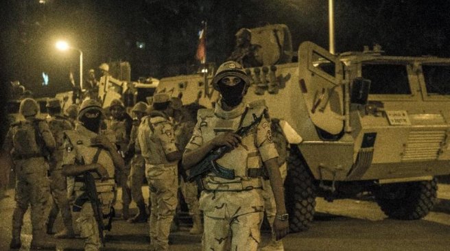 Egyptian army stand guard outside a polling station during the counting of ballots at the end of the first round of voting for Egypt's parliamentary election in Giza Cairo