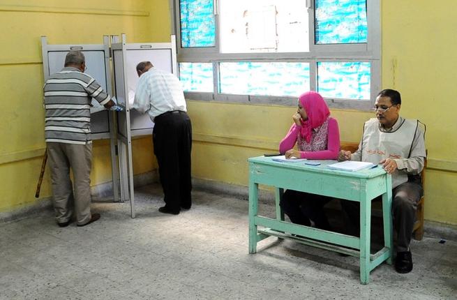 Egyptian men prepare to cast their votes in the Egyptian parliamentary elections in the port city of Alexandria