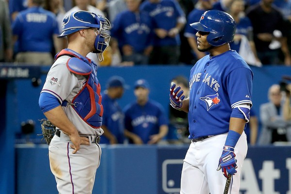 Chris Gimenez #38 of the Texas Rangers and Edwin Encarnacion #10 of the Toronto Blue Jays exchange words in the seventh inning in game five of the American League Division Series at Rogers Centre