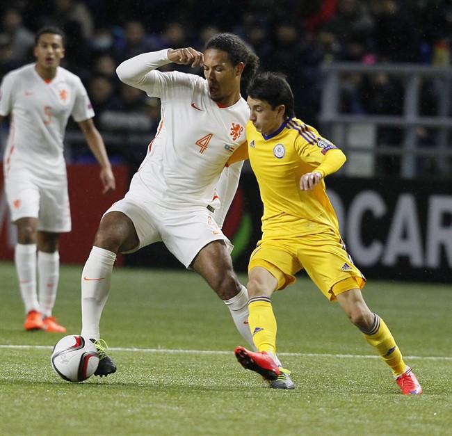 Netherlands’ Virgil Van Dijk fights for the ball with Kazakhstan's Ulan Konysbayev right during a Euro 2016 qualifying Group A soccer match between Kazakhstan and the Netherlands at the Astana Arena stadium in Astana Kazakhstan Saturday Oct. 10 20