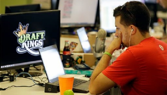 Devlin D'Zmura a tending news manager at DraftKings a daily fantasy sports company works on his laptop at the company's offices in Boston. The daily fantasy sports industry is eyeing a breakout season