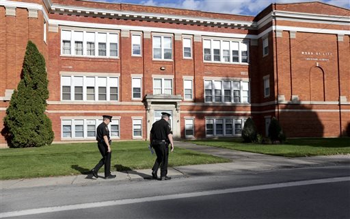 Police walk outside the Word of Life church on Thursday Oct. 15 2015 in New Hartford N.Y. Bruce and Deborah Leonard have been charged in the beating death of their son Lucas and the severe beating of his 17-year-old brother Christopher inside the