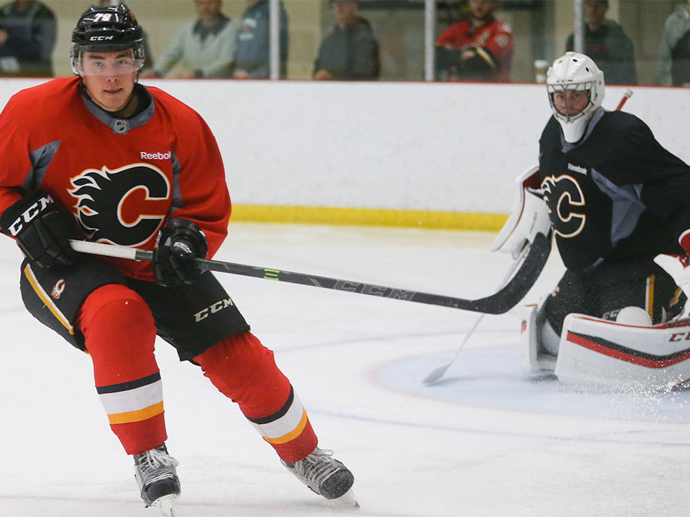 Michael Ferland left takes off towards the boards to collect a puck during Calgary Flames practice at Win Sport in Calgary on Sunday Sept. 20 2015