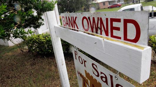 A bank owned sign is seen in front of a foreclosed home