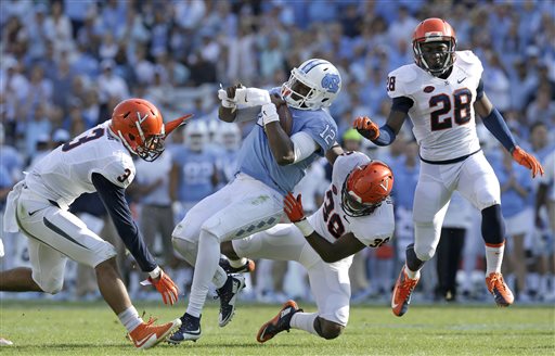 Virginia's Quin Blanding, Kelvin Rainey and Wilfred Wahee rush in to tackle North Carolina quarterback Marquise Williams during the first half of an NCAA college football game in Chapel Hill N.C. Saturday Oct. 24 2015. (AP Phot