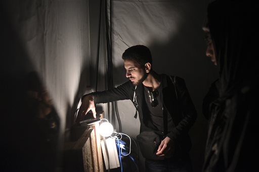 Refugees and migrants charge their cell phones inside a large tent at a refugee camp near the northern Greek village of Idomeni Monday Oct. 26 2015. European leaders decide that reception capacities should be boosted in Greece and along the Balkans migr