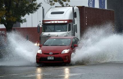 A motorist drives through flooding water in Portland Maine Wednesday Sept. 30 2015. Heavy rain has been moving through northern New England and a flood warning was issued for parts of Maine and New Hampshire