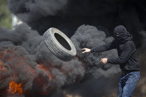 Palestinians burn tires during clashes with Israeli troops near Ramallah West Bank Friday Oct. 16 2015. Tensions and violence have been mounting in recent weeks in part fueled by Palestinian fears that Israel is trying to expand its presence at a maj