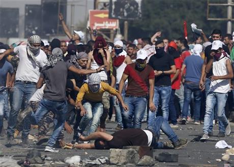 An injured Palestinian demonstrator is helped during clashes at the Hawara checkpoint near of the West Bank city of Nablus Sunday Oct. 11 2015. Tensions in he West Bank continued with near-daily violent demonstrations. At least 45 Palestinians were wou