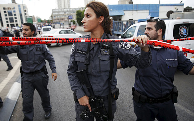 Israeli police officers patrol near a cordon at the scene of a stabbing attack in Tel Aviv Israel