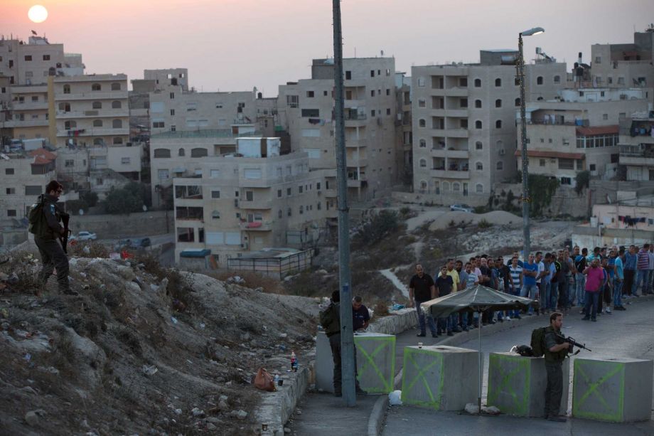 Israeli border police check Palestinians ID at a checkpoint as they exit the Arab neighbourhood of Issawiyeh in Jerusalem Sunday Oct. 18 2015. Palestinian assailants carried out a series of five stabbing attacks in Jerusalem and the West Bank on Saturd