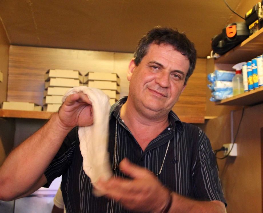 Italian Rolando del Torchio a former Roman Catholic missionary in the southern Philippines and now a restaurant owner shows a dough as he prepares to make an Italian pizza at his Ur Choice restaurant in Dipolog city Philipp