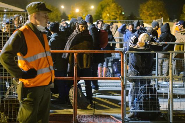 Migrants wait to board buses to be transfered to Austrian refugee centers