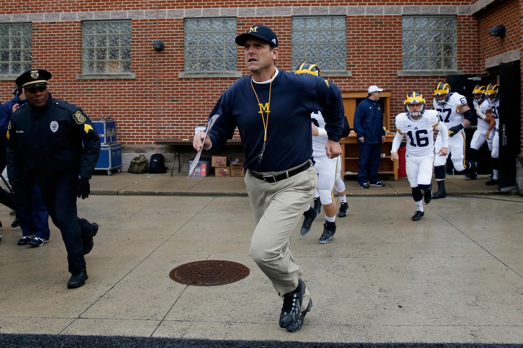 COLLEGE PARK MD- OCTOBER 03 Head coach Jim Harbaugh of the Michigan Wolverines takes the field with his team before the start of their game against the Maryland Terrapins at Byrd Stadium