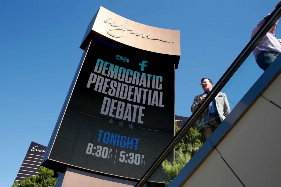 Members of the public walk under a billboard promoting the CNN Democratic presidential debate Tuesday Oct. 13 2015 in Las Vegas. Democratic presidential candidates Hillary Rodham Clinton Jim Webb Bernie Sanders Lincoln Chafee and Martin O'Malley