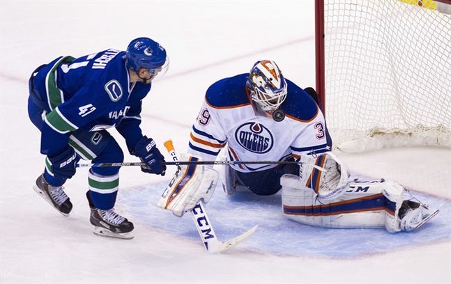 Edmonton Oilers goaltender Anders Nilsson makes a save against Vancouver Canucks Sven Baertschi during the second period of an NHL hockey game in Vancouver B.C. on Sunday