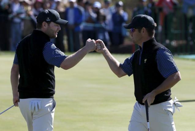 International team members Louis Oosthuizen and Branden Grace of South Africa celebrate their point against U.S. team members Jordan Spieth and Dustin Johnson on the 14th hole during the four ball matches of the 2015 Presidents Cup golf tournament