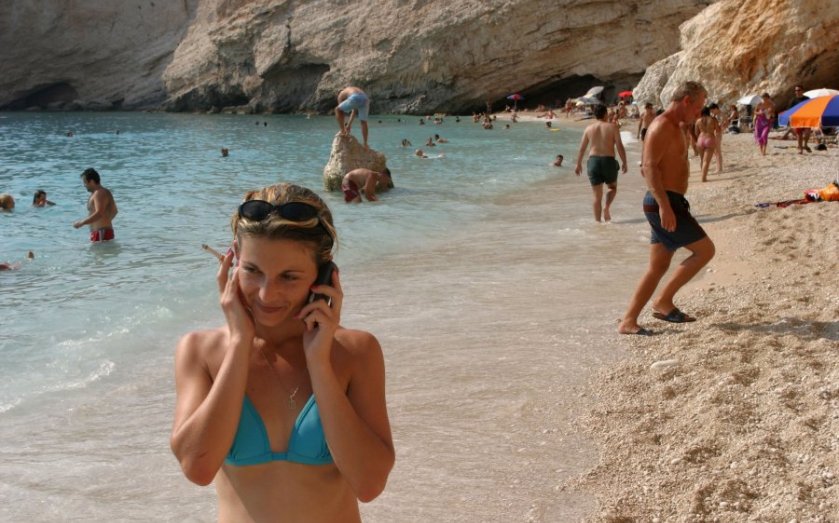 Woman using mobile phone on a beach