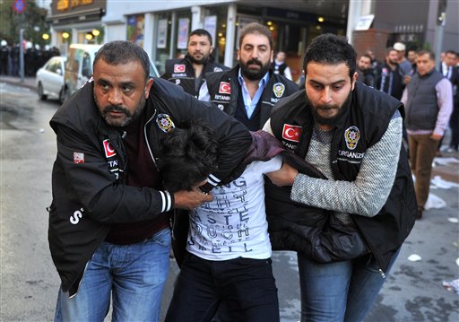 Police detain a protester as they confront protesters near the headquarters of a media company with alleged linked to a government critic where police enforced a court order to seize the business in Istanbul Oct. 28 2015. Police in Istanbul carried