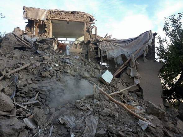 An Afghan man digs through rubble in Ramankheel village in Panjshir valley