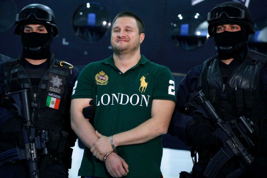 Federal Police escort Texas-born fugitive Edgar Valdez Villarreal alias'the Barbie' center during his presentation to the press in Mexico City. An official said on Wednesday Sept. 30 2015 that Mexic