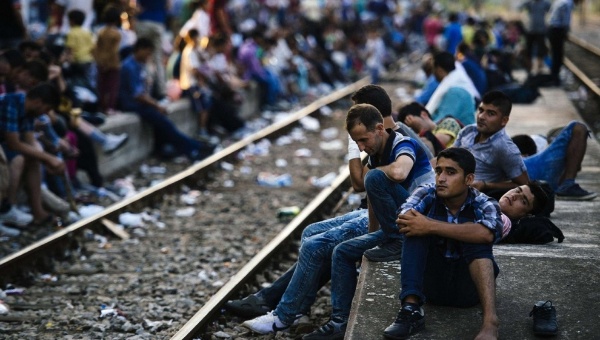 Migrants wait for a train heading to Serbia at the Gevgelija railway station on the Macedonian Greek border