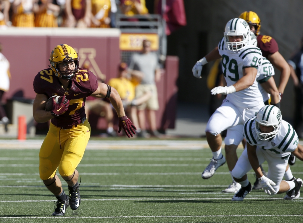 Minnesota running back Shannon Brooks leaves behind Ohio defenders on a 23-yard gain during the first half of an NCAA college football game in Minneapolis Saturday Sept. 26 2015