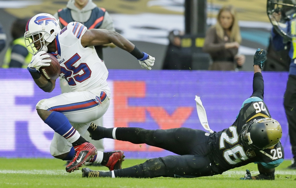 Buffalo Bills running back Le Sean McCoy, left breaks through the challenge of Jacksonville Jaguars strong safety Josh Evans during the NFL game between Buffalo Bills and Jacksonville Jaguars at Wembley Stadium in London Sunday Oct. 25 2015