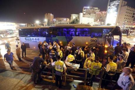 Police and medical workers ouside a bus where a Palestinian man was killed Monday after taking a police officer’s gun