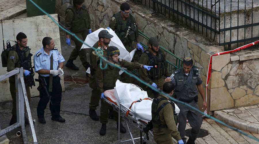 Israeli troops move on a stretcher the body of Palestinian woman who a police spokeswoman said drew a knife and approached them after she was shot by the troops in the West Bank city of Hebr