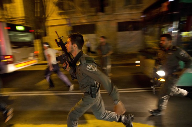 Israeli policemen run looking for a possible stabbing suspect in Jerusalem. A sudden wave of stabbing attack