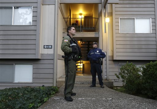 Douglas County Deputy Sheriff Greg Kennerly left and Oregon State Trooper Tom Willis stand guard outside the apartment building where alleged Umpqua Community College gunman Chris Harper Mercer lived with his mot