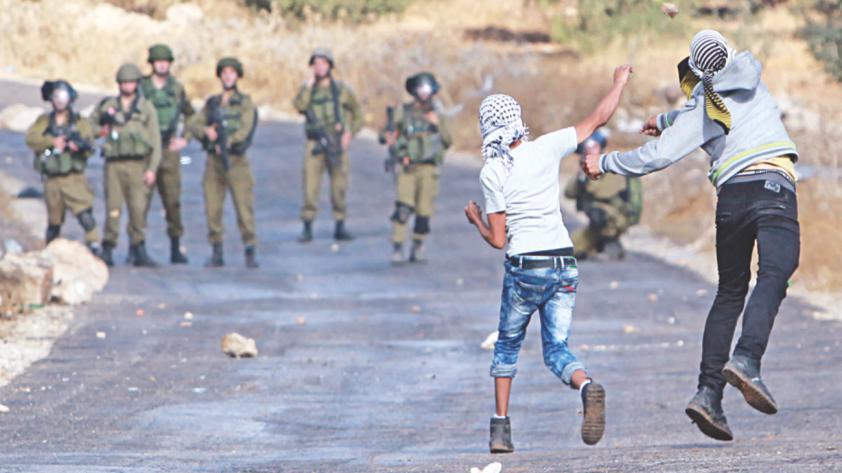 Palestinian protesters and Israeli security forces clash in the West Bank village of Tuqua south-east of Bethlehem yesterday