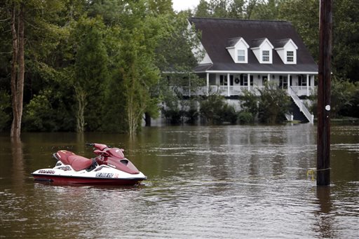 A jet ski is tied to a utility pole in the Ashborough subdivision near Summerville S.C. Monday Oct. 5 2015. South Carolina is still struggling with flood waters due to a slow moving storm system