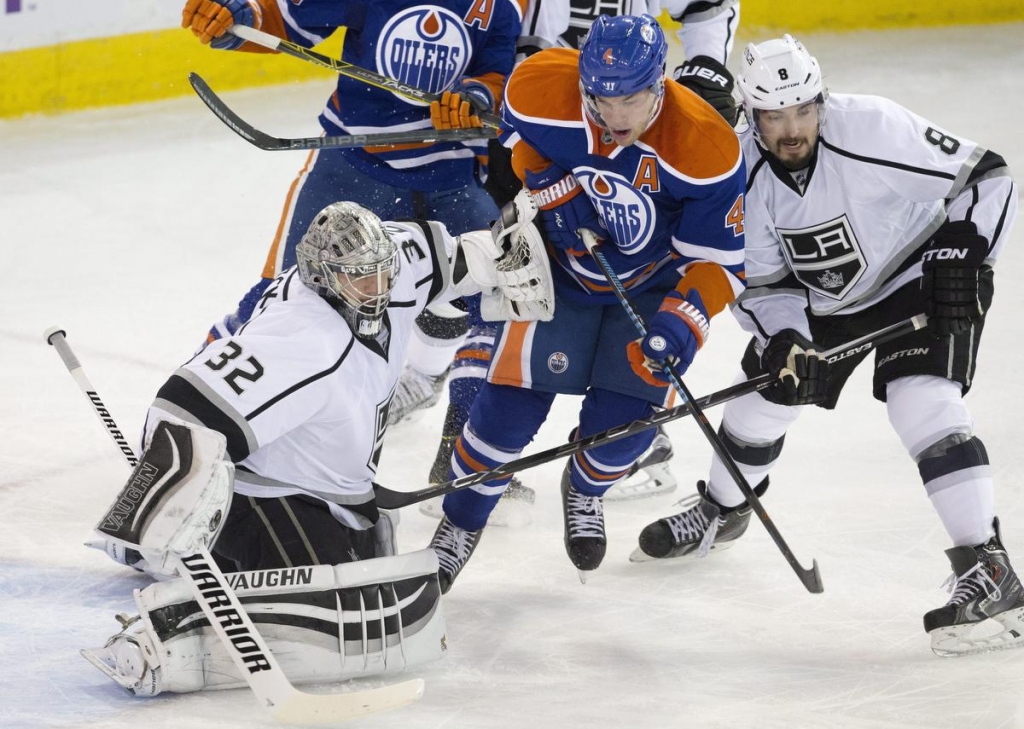 Los Angeles Kings goalie Jonathan Quick tries to clear the crease as Edmonton Oilers Taylor Hall and Drew Doughty battle in front during second period NHL action in Edmonton Alberta Sunday Oct. 25 2015