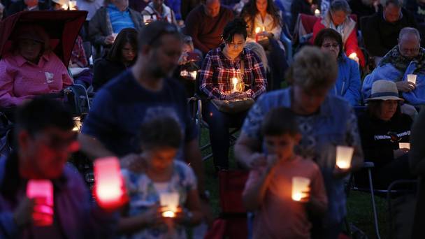 People bow their heads in prayer during a vigil in honour of the victims of the fatal shooting at Umpqua Community College