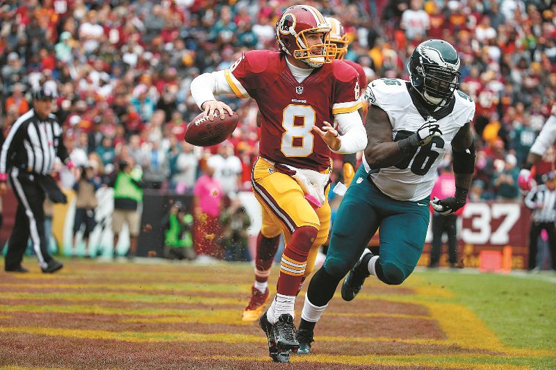 Kirk Cousins scrambles with the ball past Philadelphia Eagles nose tackle Bennie Logan during the first half. Cousins led a resilient Redskins squad on a fourth-quarter comeback