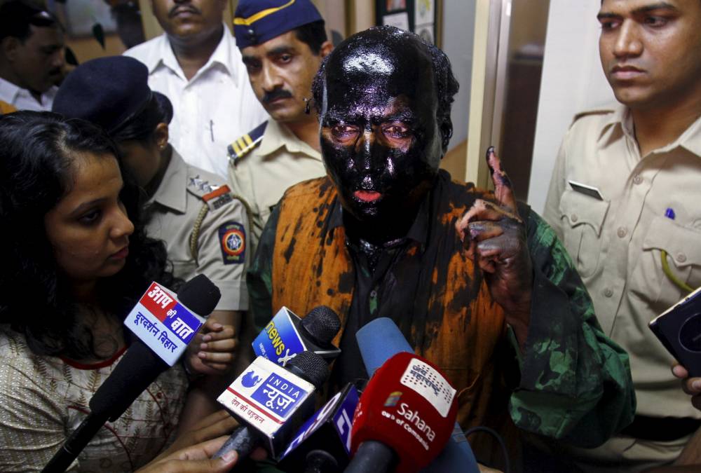 Brave activist doused in black ink by protesters- continues to make his point anyway