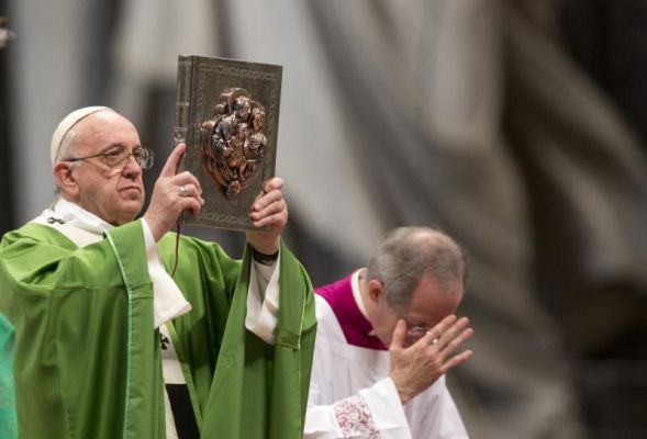 Pope Francis holds the Gospel Book as