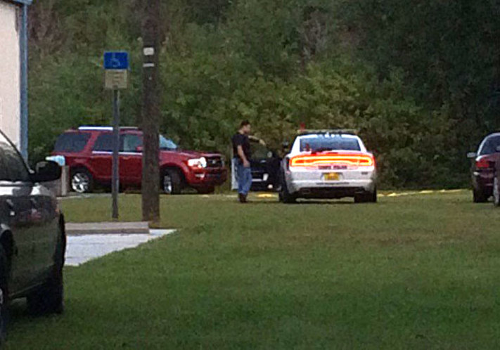 Tamp Police Department workers gather at the scene where a stolen vehicle the red SUV in the background was recovered Monday morning. One suspect was shot during a chase