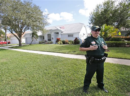 A Palm Beach County Sheriff's deputy keeps watch over the home of Palm Beach Gardens police Officer Nouman Raja Wednesday Oct. 21 2015 in Lake Worth Fla. Raja who had been investigating local burglaries stopped his unmarked car early Sunday