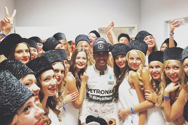 Lewis Hamilton poses with the Russian grid girls after his victory