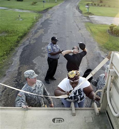 Josephine Winns climbs aboard a vehicle from the South Carolina National Guard as she takes part in a voluntary evacuation from the Oatland and Dunbar S.C. communities Thursday Oct. 8 2015. As the Black River rises the homes in the two neighborhoods