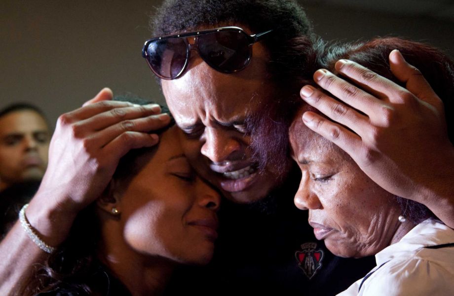 Kansas City Royals player Edinson Volquez center embraces his sister Wendy Volquez left and mother Ana Ramirez as they stand next to the body of his father Daniel Volquez during his wake at a funeral home in Santo Domingo Dominican Republic Wednesda